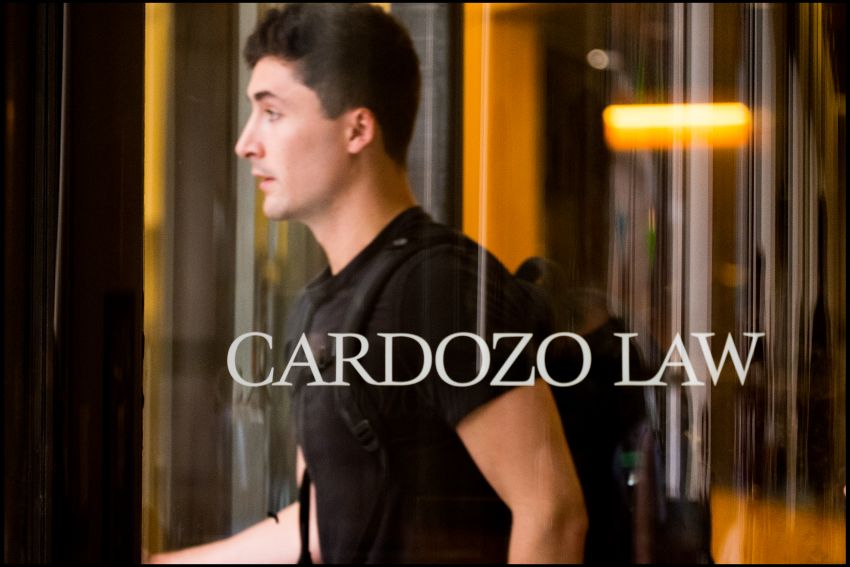 Revolving door Male student walking through Revolving door with cardozo logo on glass