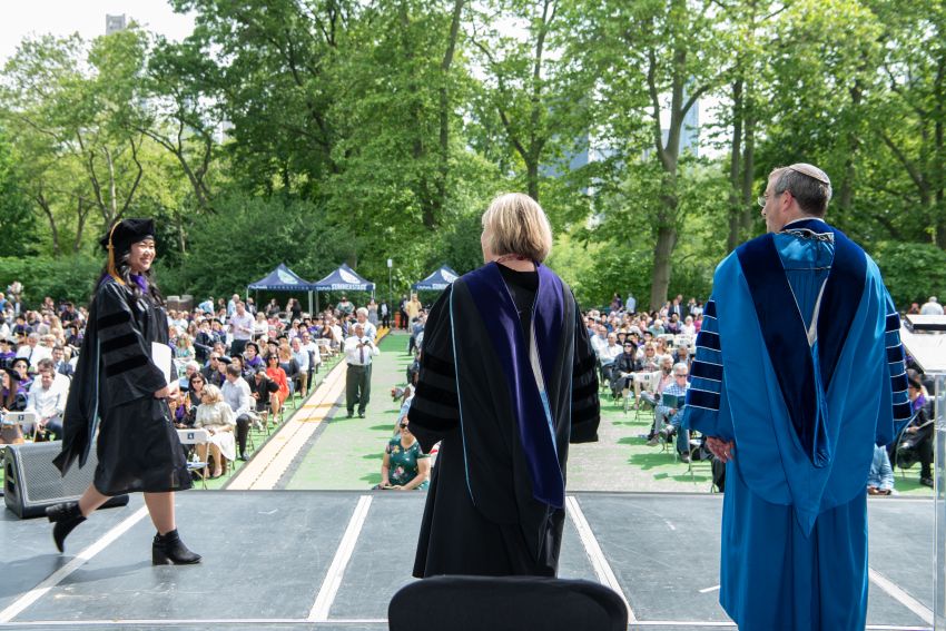 Student crossing the stage to receive her diploma