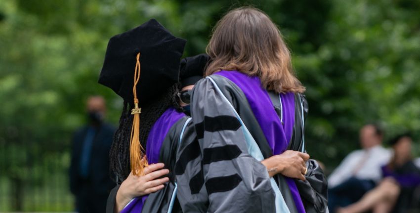students hugging at commencement