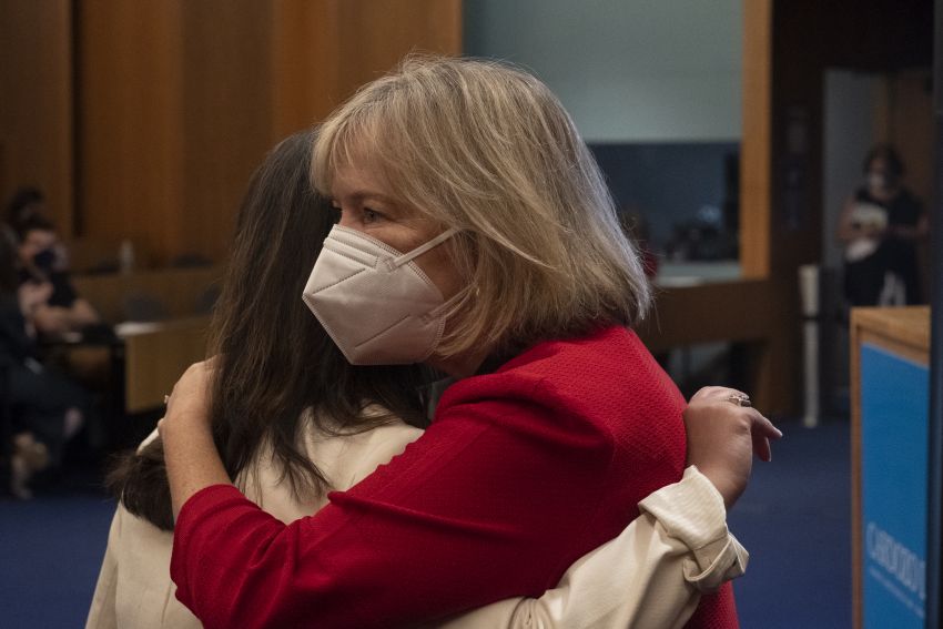 Dean Leslie wearing a mask as she hugs a student
