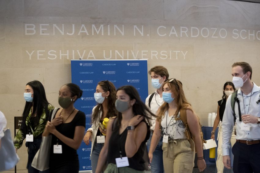 Students wearing masks walk in lobby
