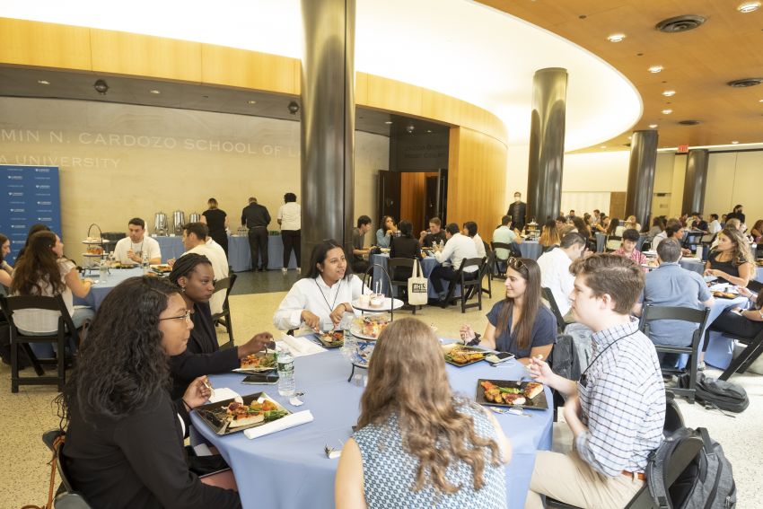 students eating at tables in the lobby